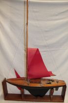 An old wooden model pond yacht with weighted keel and nylon sails,