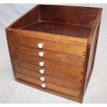 A stained wood table top collector's cabinet of six shallow fitted drawers,
