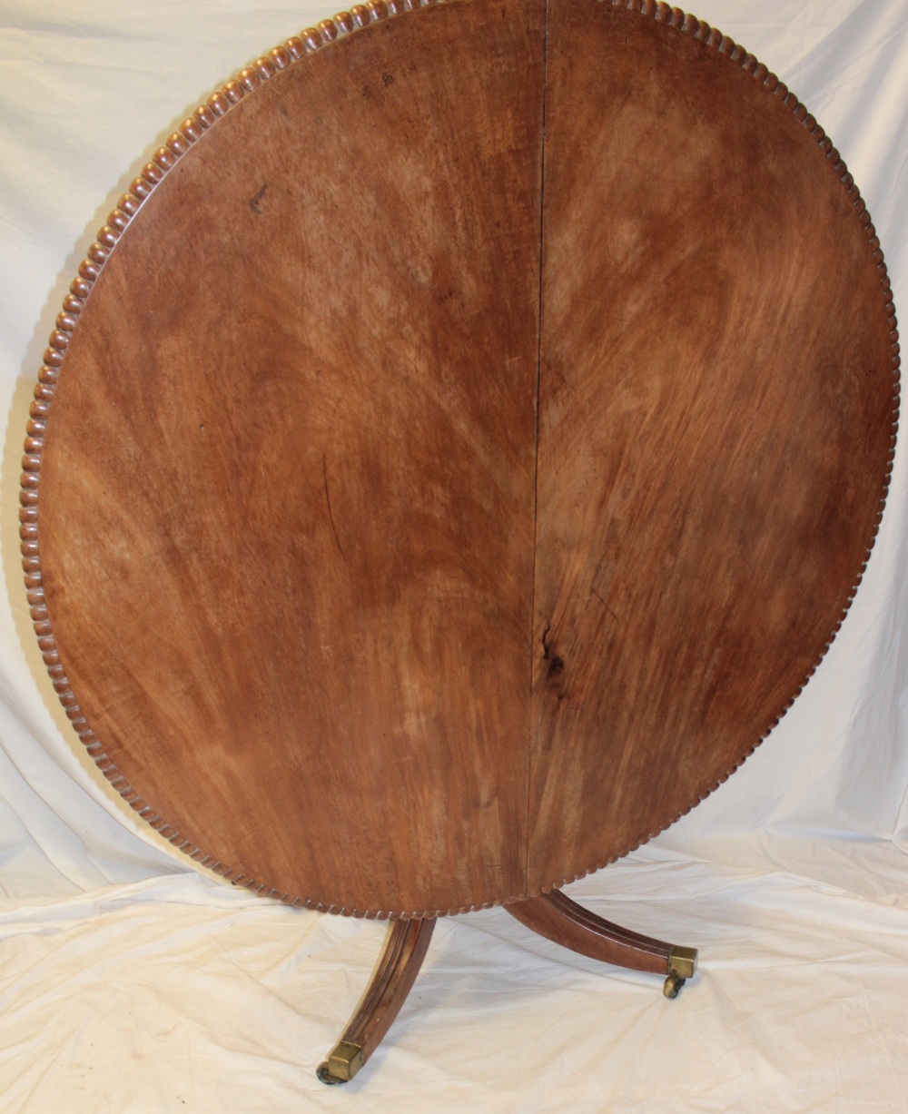 An early to mid 19th century figured mahogany turn-over-top breakfast table with fluted edge,