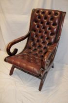 A good quality reproduction mahogany open arm easy chair upholstered in buttoned brown leather