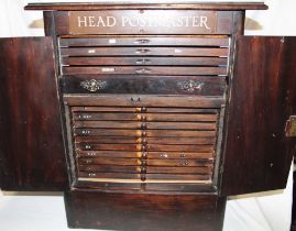 An unusual postmaster's collector's cabinet of fourteen shallow drawers and one standard drawer