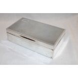 A George V silver rectangular cigarette box with engine turned decoration and engraved initials,