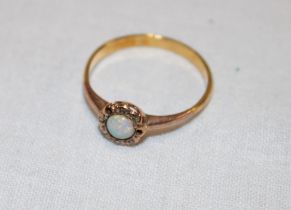 A small 18ct gold dress ring set opal surrounded by diamond chips (1.