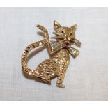 A 9ct gold brooch in the form of a seated cat mounted with sapphires, a ruby and diamond chips (4.