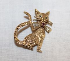 A 9ct gold brooch in the form of a seated cat mounted with sapphires, a ruby and diamond chips (4.