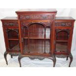 A late Victorian carved mahogany break-front parlour cabinet with three frieze drawers and