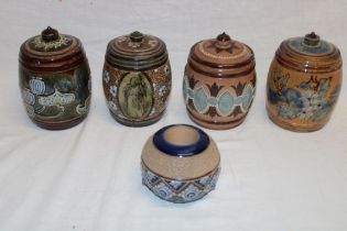 Four Doulton Lambeth pottery cylindrical tobacco jars and covers with raised decoration,