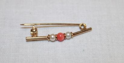 An unmarked gold tie-pin set coral and seed pearls