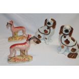 A pair of Victorian Staffordshire pottery figures of greyhounds with hare on oval bases (one af),