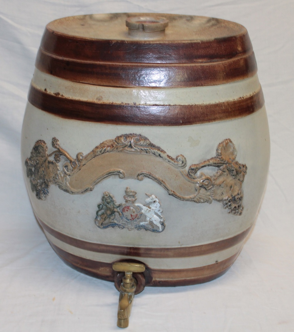 A large 19th century painted stoneware barrel with raised coat of arms and brass tap,