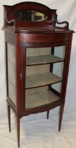 A late Victorian inlaid mahogany bow fronted display cabinet with fabric lined shelves enclosed by