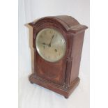 A German mantel clock with silvered circular dial in oak arched case