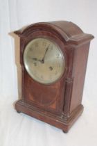 A German mantel clock with silvered circular dial in oak arched case