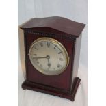 An Edwardian mantel clock with silvered circular dial in polished mahogany rectangular case