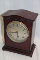 An Edwardian mantel clock with silvered circular dial in polished mahogany rectangular case