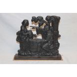 An old cast-iron door stop in the form of figures at a well,