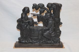 An old cast-iron door stop in the form of figures at a well,
