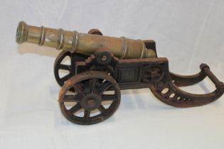 A brass ornamental cannon with 11" tapered barrel on cast-iron carriage