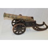 A brass ornamental cannon with 11" tapered barrel on cast-iron carriage