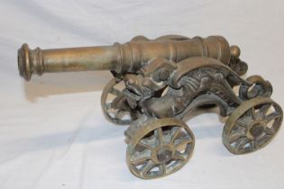 A cast brass model cannon with 14½" barrel on brass four-wheel carriage