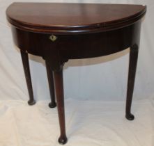 A George III mahogany semi-circular turn-over-top table with plain apron on tapered legs with pad