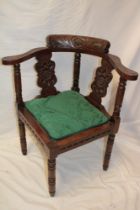A 19th century carved oak corner chair with splat back and upholstered seat on turned legs