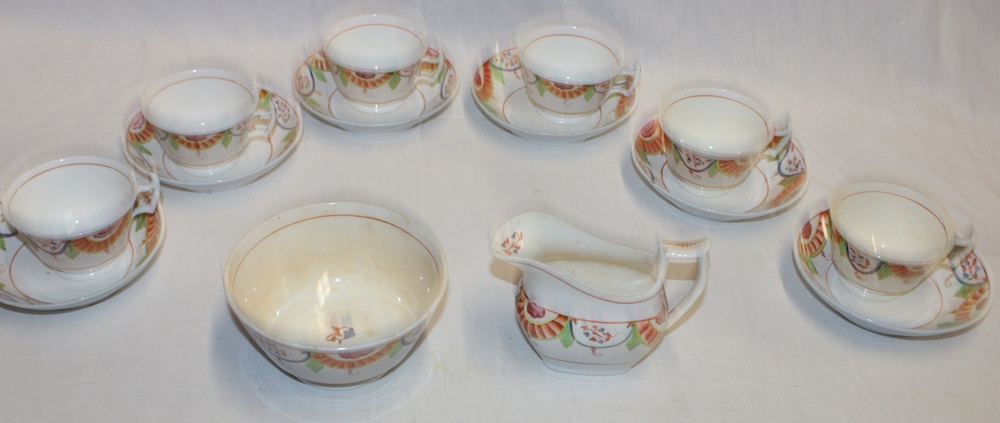 An early 19th century china tea set comprising six tea cups with painted angular rims, six saucers,