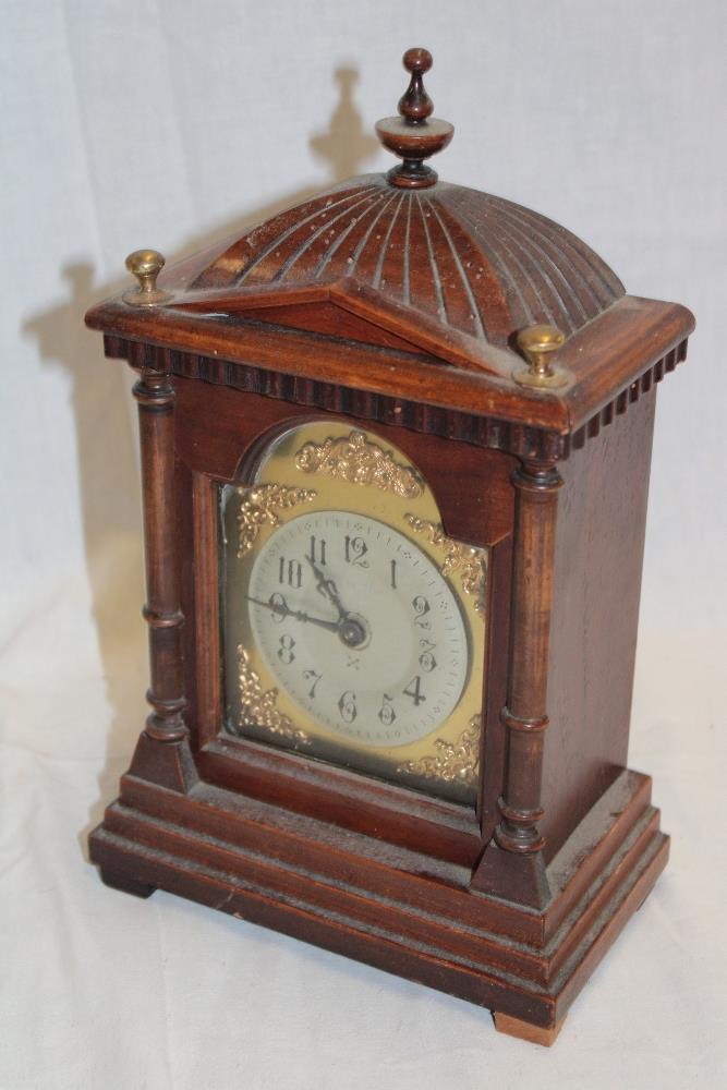 A German mantel clock with silvered and gilt arched dial in walnut and brass mounted case