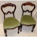 A pair of Victorian carved mahogany balloon-back dining chairs with upholstered seats on turned