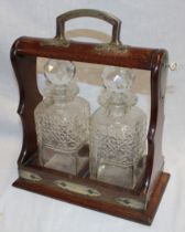 An oak and silver-plated twin bottle tantalus containing a pair of matching cut-glass square