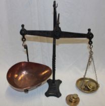 An old iron balance scales with brass and copper pans and a selection of brass weights