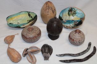 A carved coconut container and cover from Jamaica, two painted nuts from Belize,
