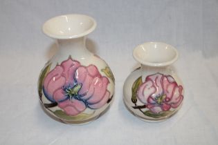 A Moorcroft pottery tapered vase with floral decoration on white ground,