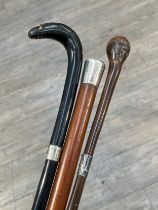 A silver topped George V walking cane with horn tip and a further two walking canes with white metal