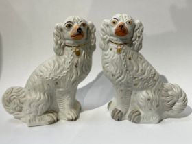 A pair of 19th Century Staffordshire fireside spaniels, well moulded, white enriched with gilt, 30.