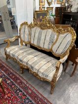 An early 20th Century French giltwood three piece suite with silk upholstery, some gilding is