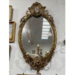 A late 18th / early 19th Century gilt gesso girandole wall mirror, the arched pediment with