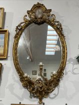 A late 18th / early 19th Century gilt gesso girandole wall mirror, the arched pediment with