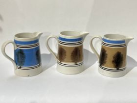Three Quart Mocha ware jugs, one blue and two pale brown, one with crack to spout, 16cm talk