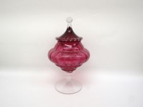 A cranberry glass lidded jar on pedestal base, one piece of prunt work damaged, 33cm tall