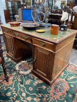 A late Victorian walnut twin pedestal desk, the green tooled leather three section top over three