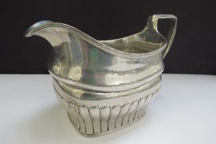 An early 19th Century Irish silver milk jug, stirrup handle and fluted detail, sea creature designed