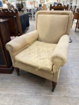 A late Victorian armchair, the scroll arms and feather filled cushion on ring turned tapering oak