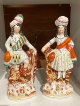 A pair of 19th century Staffordshire highland figures with lambs to base, 27cm & 26cm tall