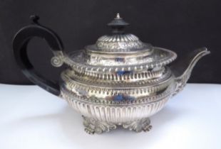 A William Fountain silver teapot embossed foliate borders, reeded half body, raised on four scroll