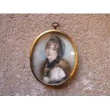 A 19th Century watercolour on oval ivory panel of a young woman with fur collar. Unsigned. Brassed