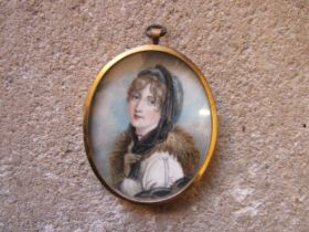 A 19th Century watercolour on oval ivory panel of a young woman with fur collar. Unsigned. Brassed