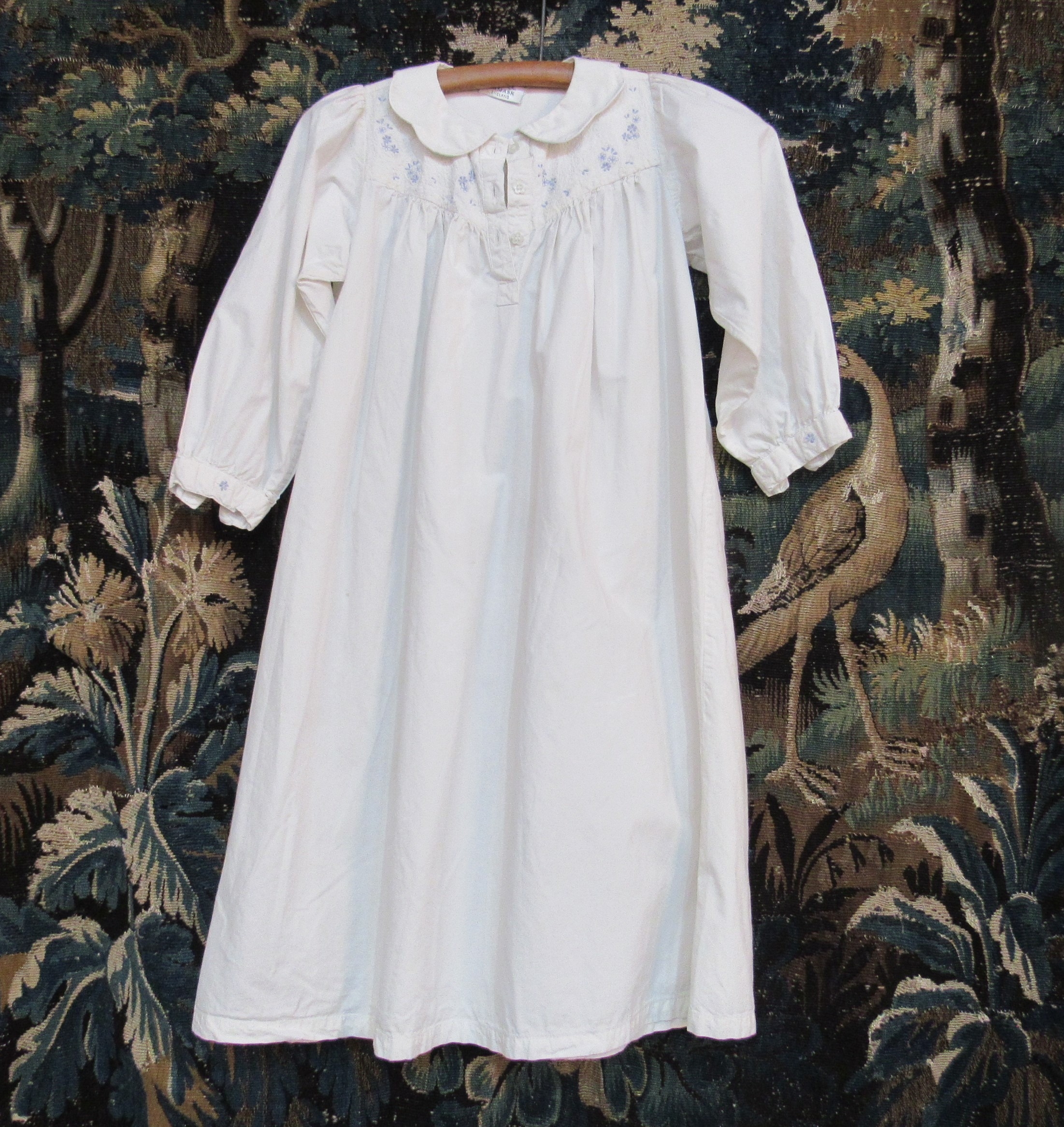 A "Damask England" crisp white cotton child's nightdress, the yoke embroidered with pale blue