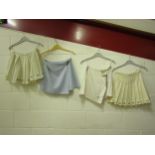 Three vintage Fred Perry pleated tennis skirts in white and cream, all bearing the iconic Fred Perry