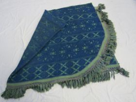 A heavy blue and green cotton bedspread with deep fringing